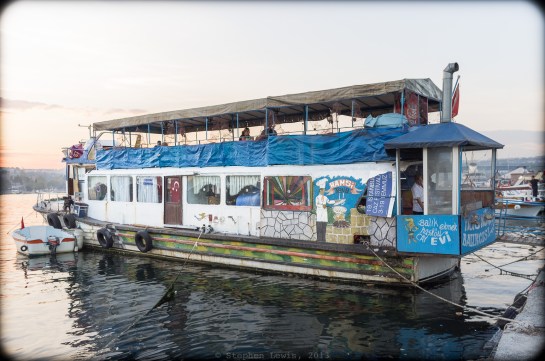 An anchored boat converted to a fish sandwich and fried anchovy restaurant, Golden Horn, Hasköy, Istanbul, 2013.  Note the kitchen topped with jaunty chimney  perched precariously in the after-fitted poop-deck. (Fuji X100)  Click to enlarge.